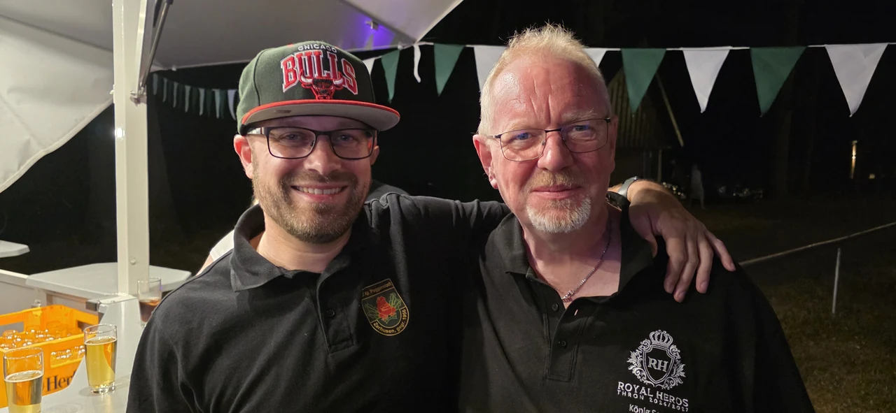 Zwei Gäste am Zelt am späten Abend, rechts im Poloshirt des Throns Royal Heroes